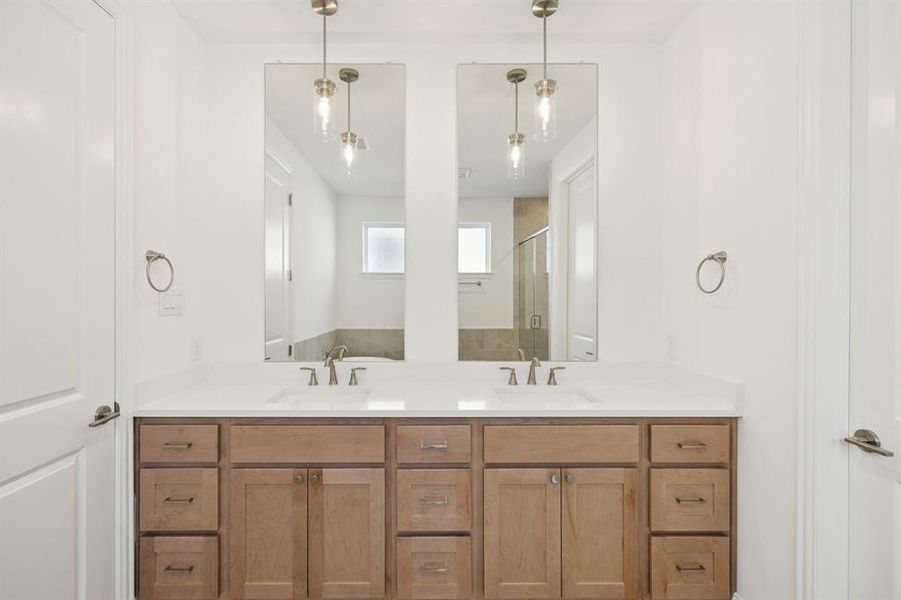 Primary bathroom featuring double vanity and a stall shower