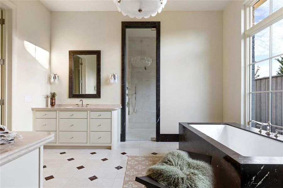 Bathroom with a walk in shower, light tile patterned floors, two vanities, and a bath Bathroom with a walk in shower, light tile patterned floors, two vanities, and a bath