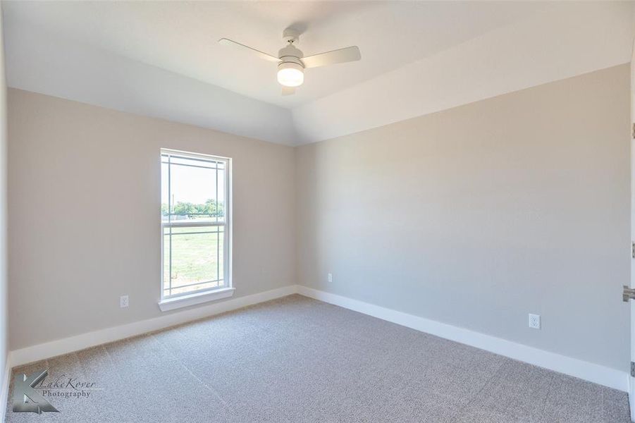 Empty room featuring light colored carpet and ceiling fan