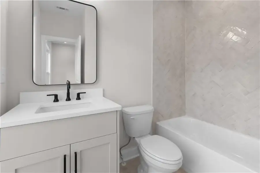 Vanity with an integrated sink, matte black faucet, and a rectangular mirror
