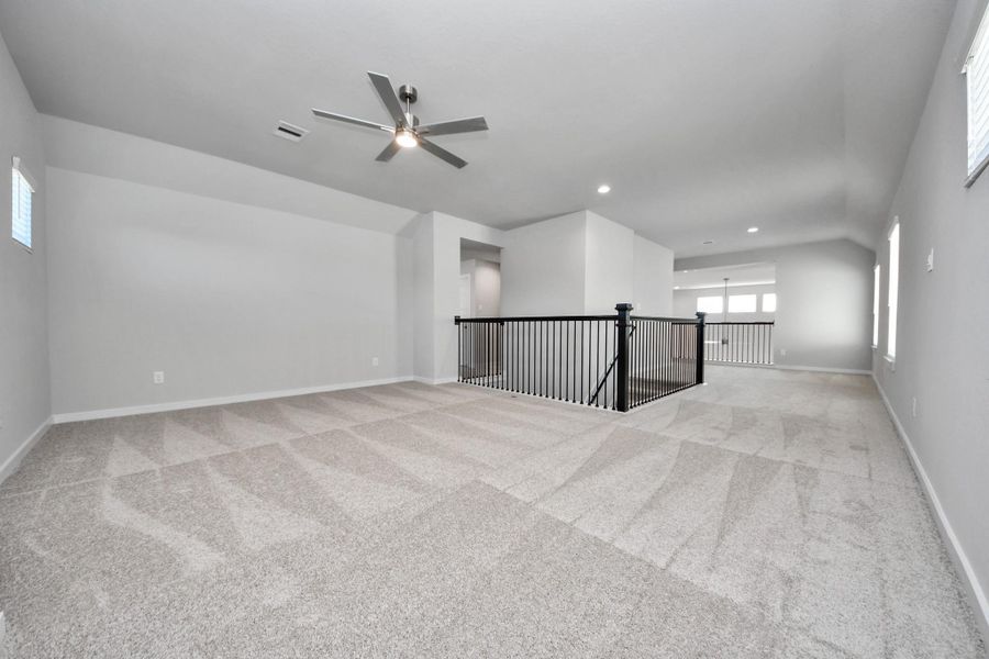 Come upstairs and enjoy a day of leisure in this fabulous game room! This is the perfect hangout spot or adult game room! Features plush carpet, high ceilings, custom paint and windows for plenty of natural light. Sample photo of completed home with similar floor plan. Actual colors and selections may vary. Come upstairs and enjoy a day of leisure in this fabulous game room! This is the perfect hangout spot or adult game room! Features plush carpet, high ceilings, custom paint and windows for plenty of natural light. Sample photo of completed home with similar floor plan. Actual colors and selections may vary.