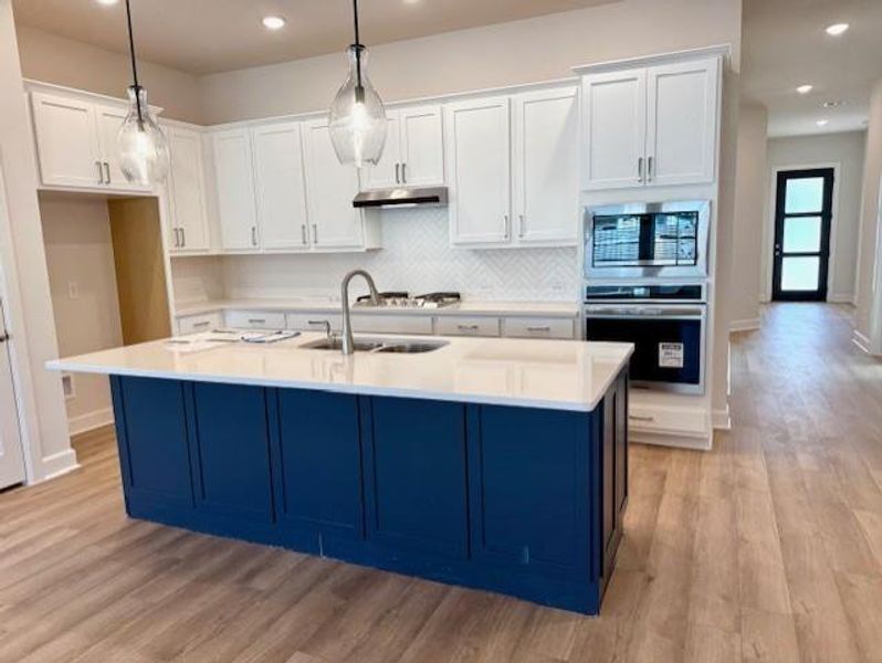 Gorgeous Kitchen with Quartz counters, gas cooktop, updraft vent hood & separate oven/micro