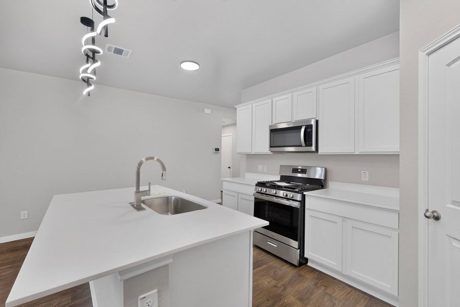 An open kitchen layout is enhanced by a central island and recessed lighting.