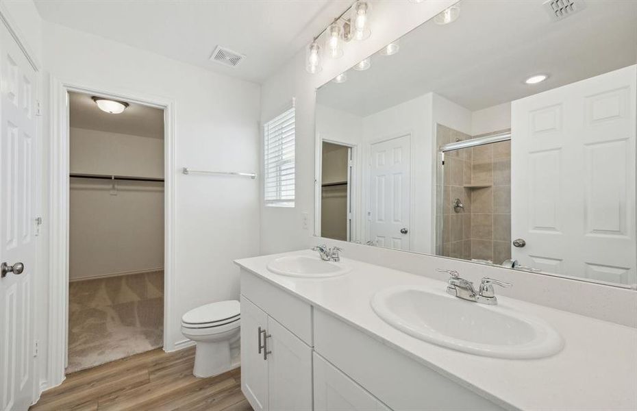 Elegant owner's bathroom with dual vanity and oversized shower*real home pictured