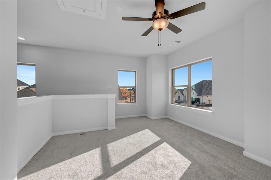 Unfurnished room featuring a ceiling fan and light carpet Unfurnished room featuring a ceiling fan and light carpet