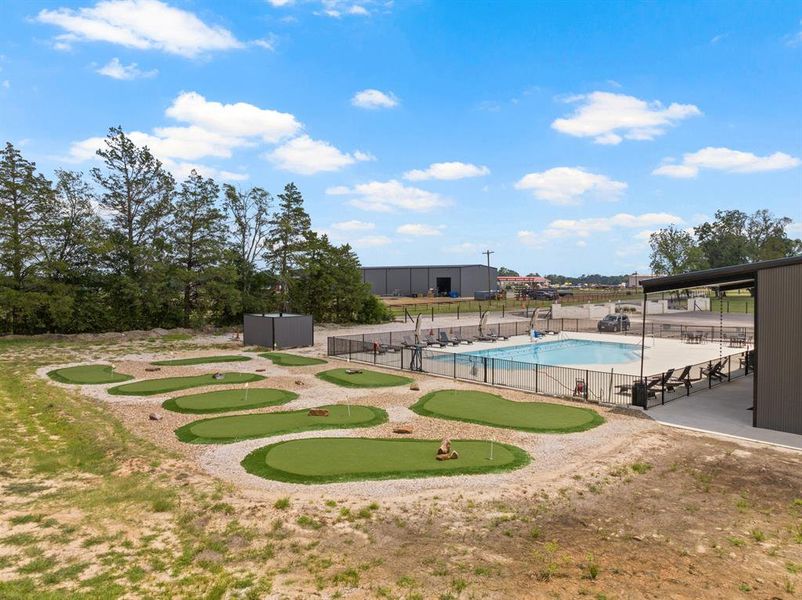 Community pool with an area to practice putting and a patio area