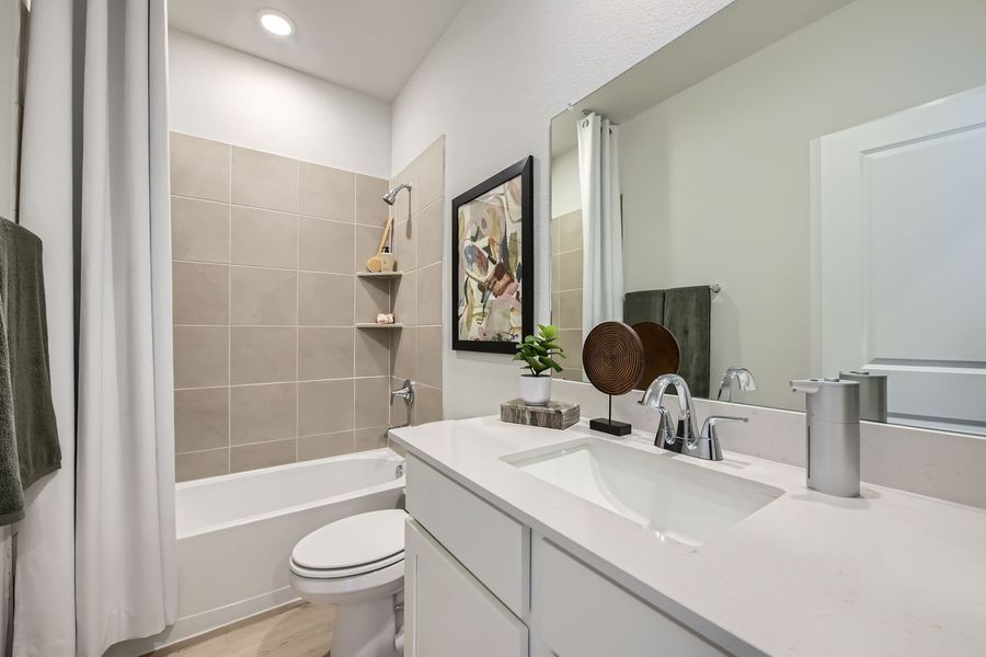 A bathroom with a sink toilet and a mirror. A bathroom with a sink toilet and a mirror.