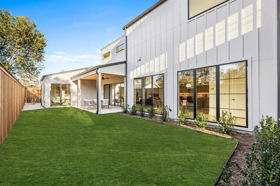 Back of property featuring a lawn, a patio area, and ceiling fan