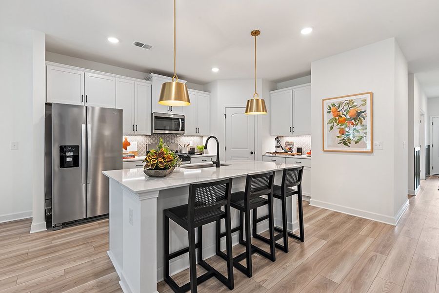 A kitchen with a dining table and a refrigerator. A kitchen with a dining table and a refrigerator.
