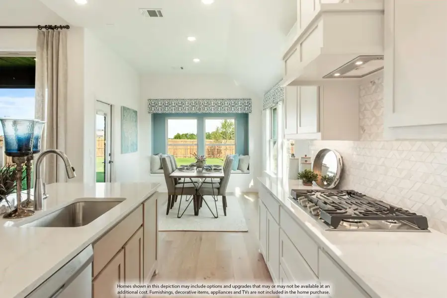 Kitchen with white cabinets, quartz countertops, gas cooktop, and breakfast nook with built-in bench seating