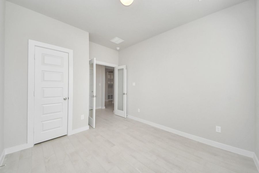 At the forefront, a refined home office beckons productivity and focus. Luxurious details like elegant tile flooring, custom paint, expansive windows with privacy blinds, and French doors create an inspiring workspace. Sample photo of completed home with similar floor plan. Actual colors and selections may vary.