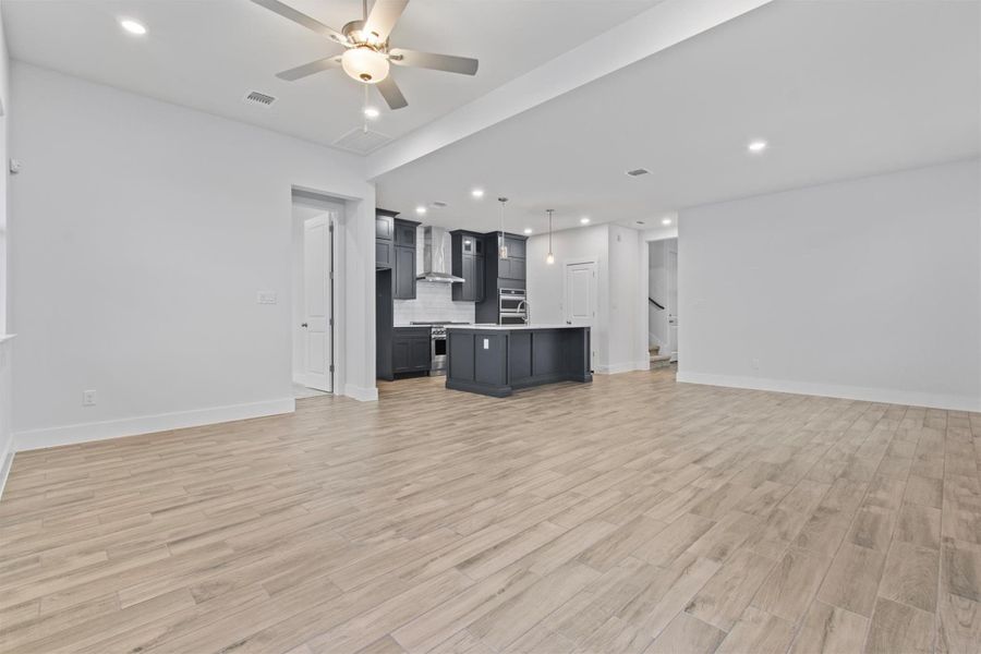 Unfurnished living room with ceiling fan and light hardwood / wood-style floors