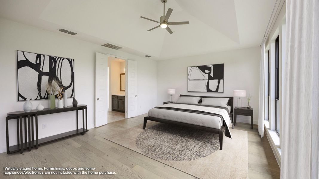 Bedroom featuring a tray ceiling, light wood-type flooring, ceiling fan, and ensuite bathroom Bedroom featuring a tray ceiling, light wood-type flooring, ceiling fan, and ensuite bathroom