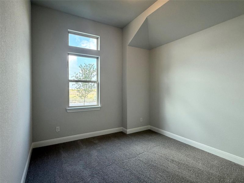 Empty room with healthy amount of natural light and dark colored carpet Empty room with healthy amount of natural light and dark colored carpet