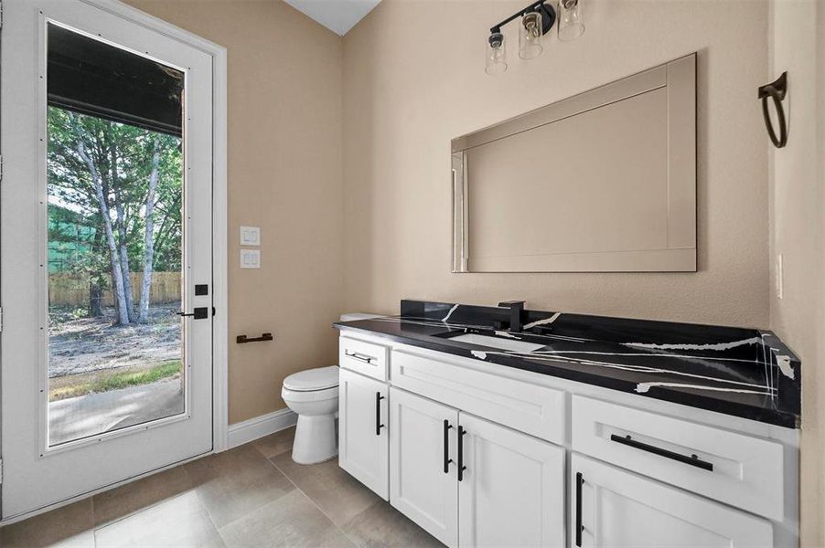 Bathroom with vanity, tile patterned floors, and toilet