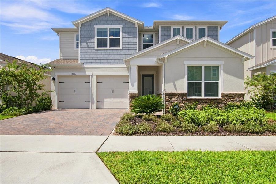 Front exterior of a new home in Horizon Isle, Winter Garden, FL, highlighting curb appeal (Image 2). Front exterior of a new home in Horizon Isle, Winter Garden, FL, highlighting curb appeal (Image 2).