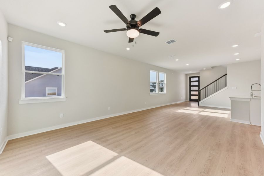 A room with a wood floor and a ceiling fan. A room with a wood floor and a ceiling fan.