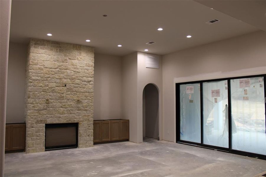 Unfurnished living room with a stone fireplace