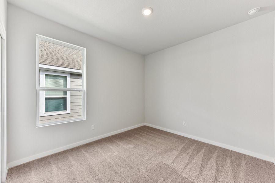 A room with a window and a carpet.