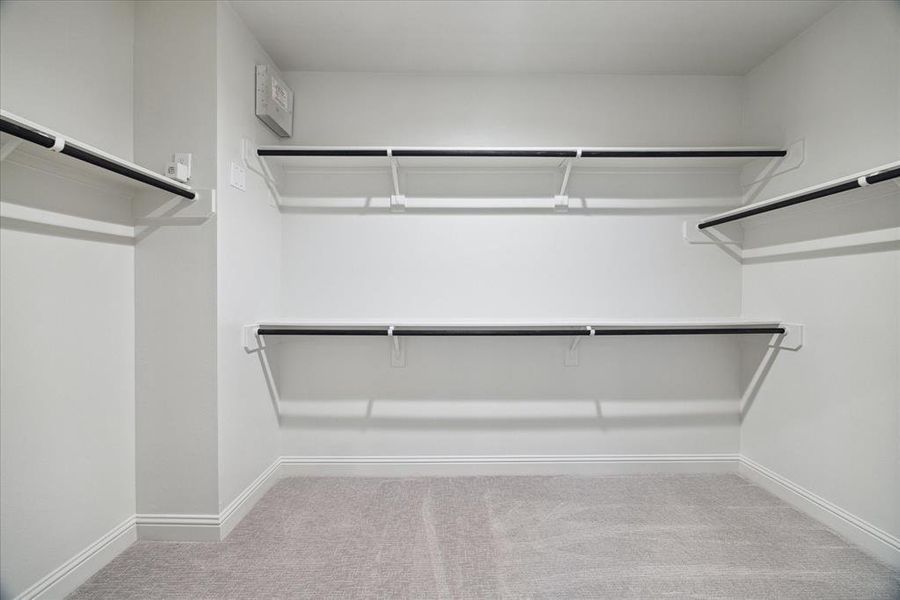 Additional walk-in closet within the primary bathroom, offering extra storage and organization options.