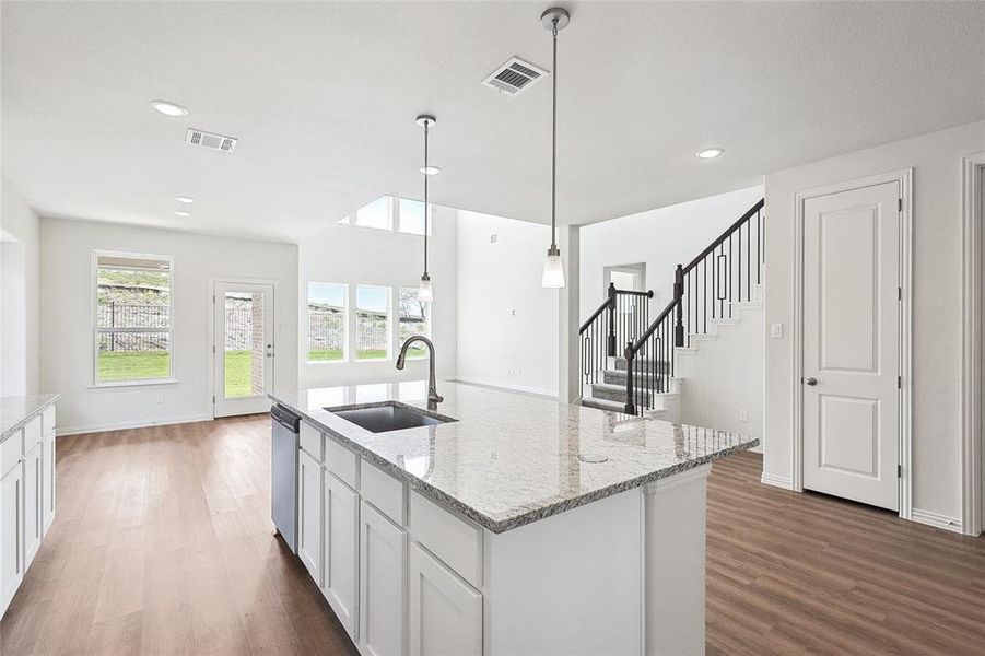 Kitchen with white cabinetry, sink, decorative light fixtures, and dark hardwood / wood-style flooring