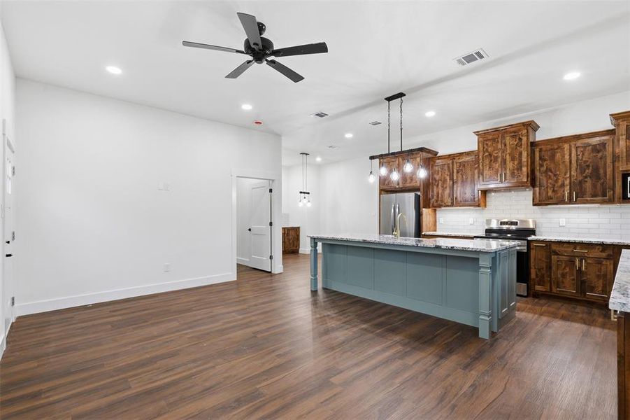 Open-concept living space featuring wood-finish flooring, recessed lighting, and a contemporary ceiling fan Open-concept living space featuring wood-finish flooring, recessed lighting, and a contemporary ceiling fan