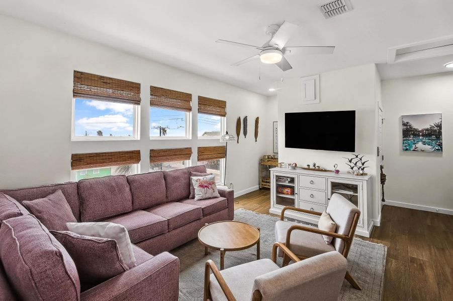 Living room featuring wood finished floors and a ceiling fan Living room featuring wood finished floors and a ceiling fan