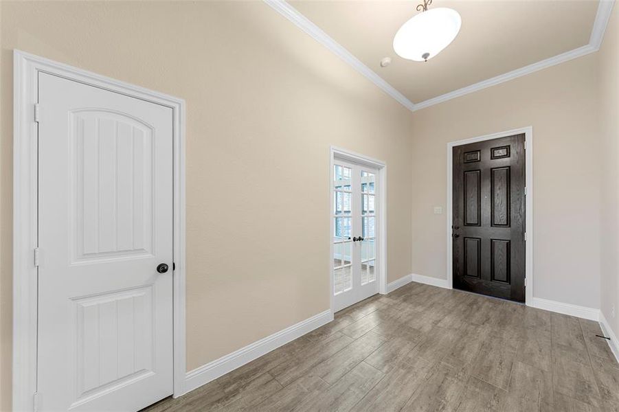 Entryway featuring ornamental molding, baseboards, wood finished floors, and french doors