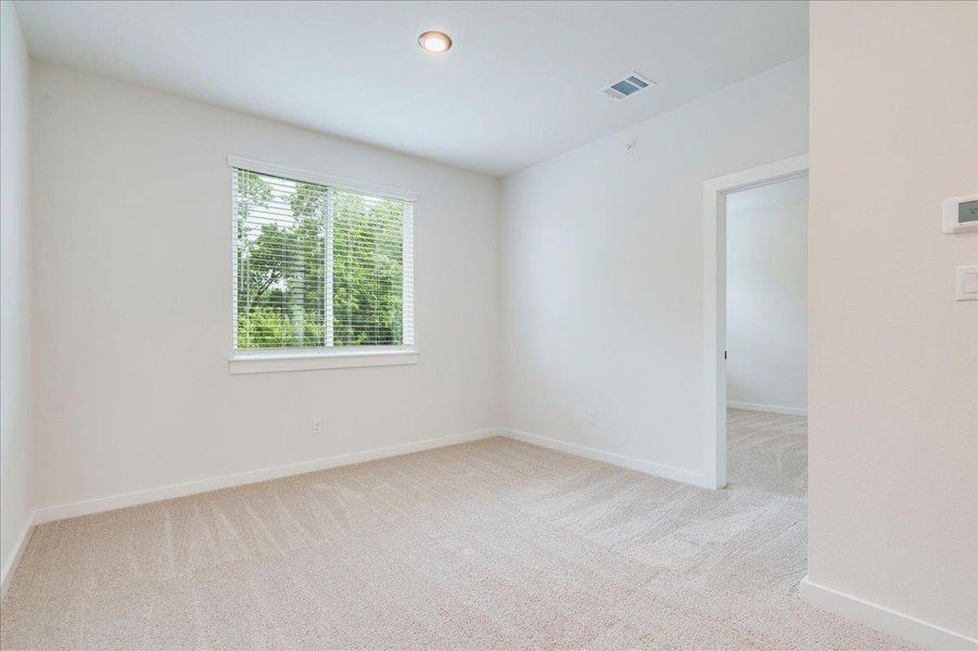 Sun-filled room with plush carpet flooring awaits your personal touch.