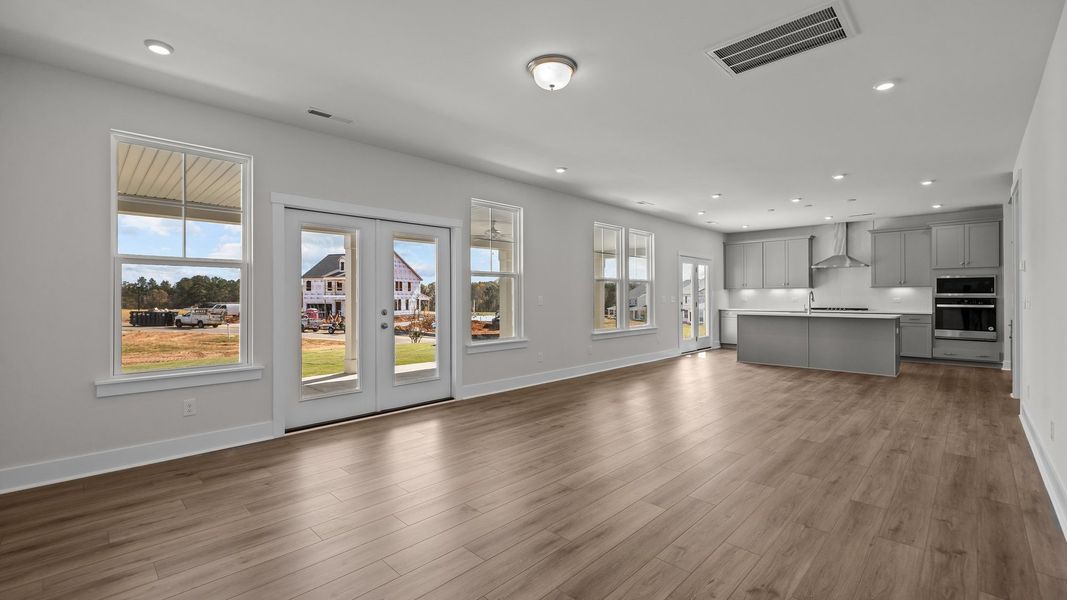 Burton Design open floor concept kitchen, dining, and family room. at Lakeside Glen by premier builder DRB Homes in York, SC.