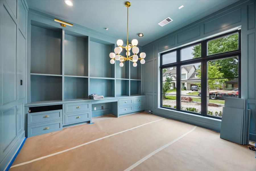 Downstairs home office/study with built-in cabinetry and paneled walls. Pictured April 2026.