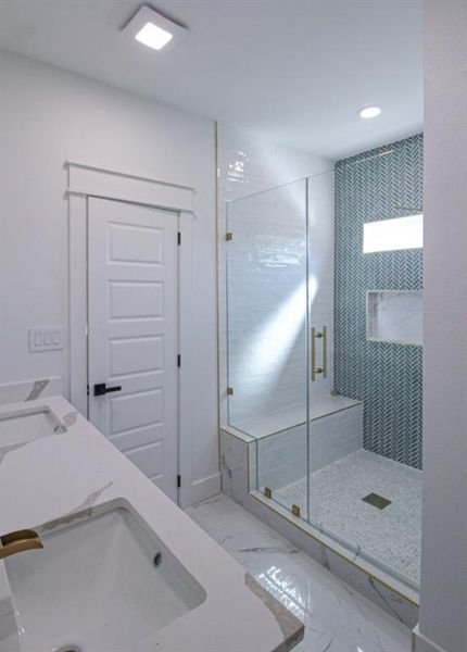 Bathroom with a stall shower, light marble finish floors, double vanity, and recessed lighting Bathroom with a stall shower, light marble finish floors, double vanity, and recessed lighting