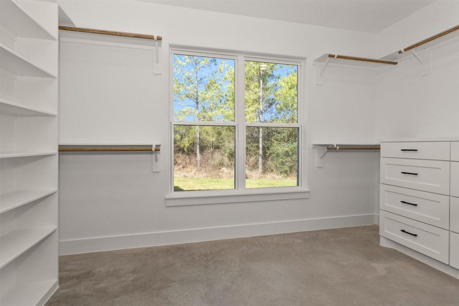 The spacious primary closet is thoughtfully designed with built-in shelving and drawers, providing abundant storage and organization for every wardrobe need.