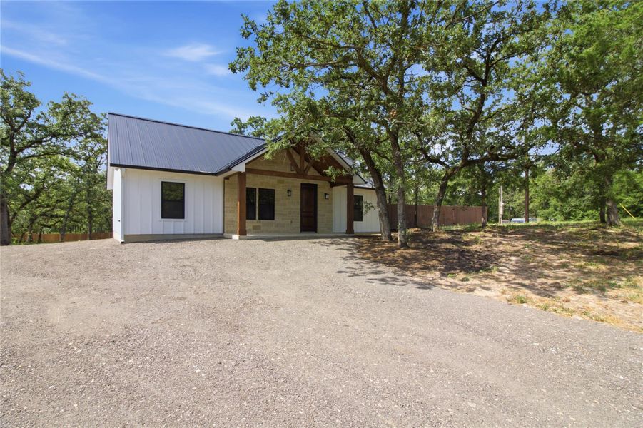 ONE ACRE - A charming single-story residence with a metal roof nestled amidst mature trees. ONE ACRE - A charming single-story residence with a metal roof nestled amidst mature trees.