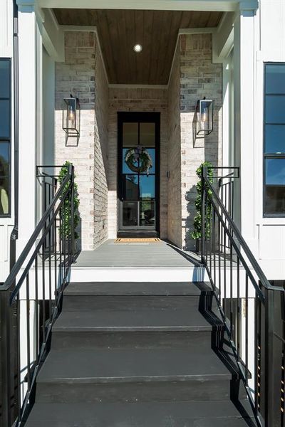 Front entry with elegant lantern-style lighting and a modern black door.