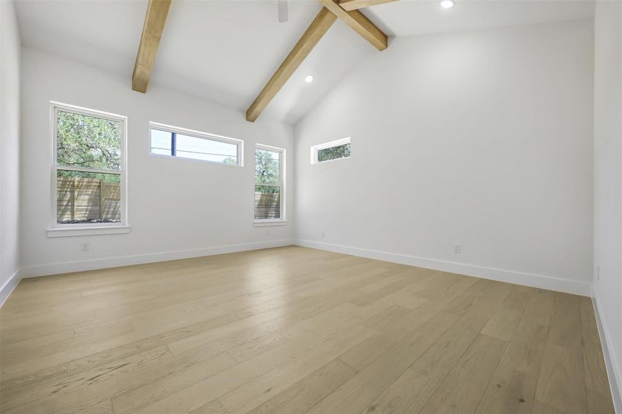 Unfurnished room with light wood finished floors, beamed ceiling, recessed lighting, and high vaulted ceiling