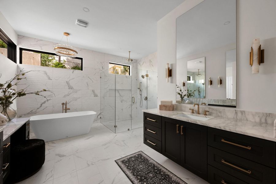 Spa-inspired indulgence. A standalone soaking tub serves as the centerpiece of this sun-drenched, wellness-oriented ensuite