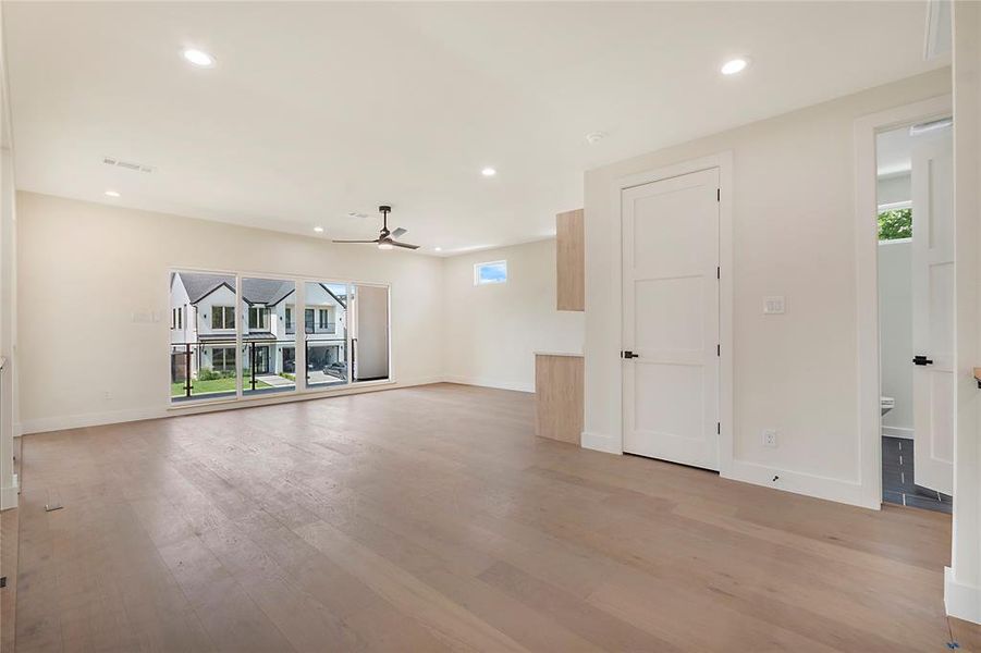 Unfurnished living room featuring ceiling fan and hardwood / wood-style floors