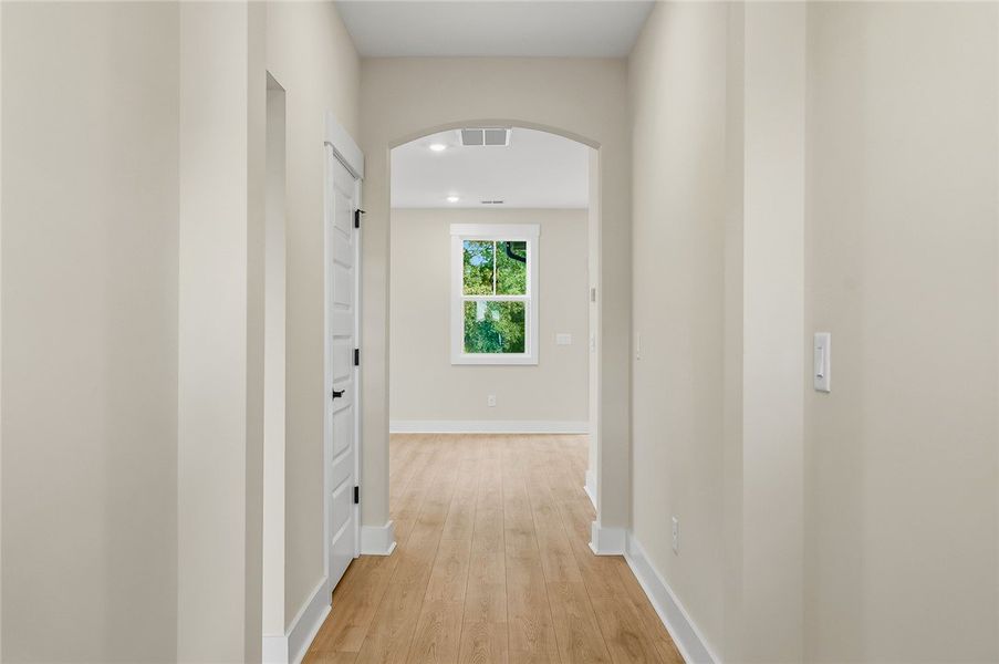 An arched doorway leads from the wood-floored hall