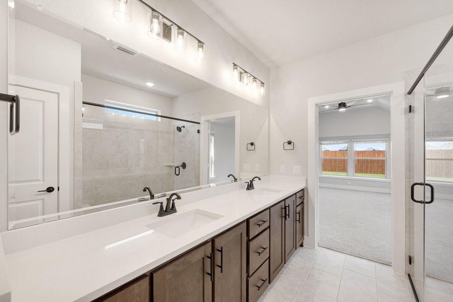 Master bathroom with double vanity, white quartz countertop, dark wood cabinets, and glass walk-in shower Master bathroom with double vanity, white quartz countertop, dark wood cabinets, and glass walk-in shower