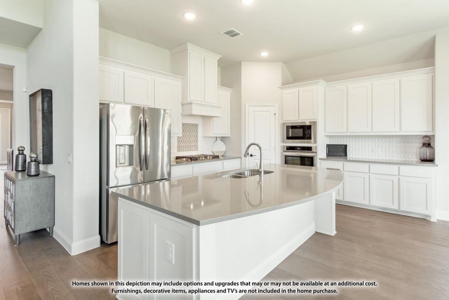 Kitchen with white cabinets, large center island with sink, stainless steel appliances, and hardwood floors