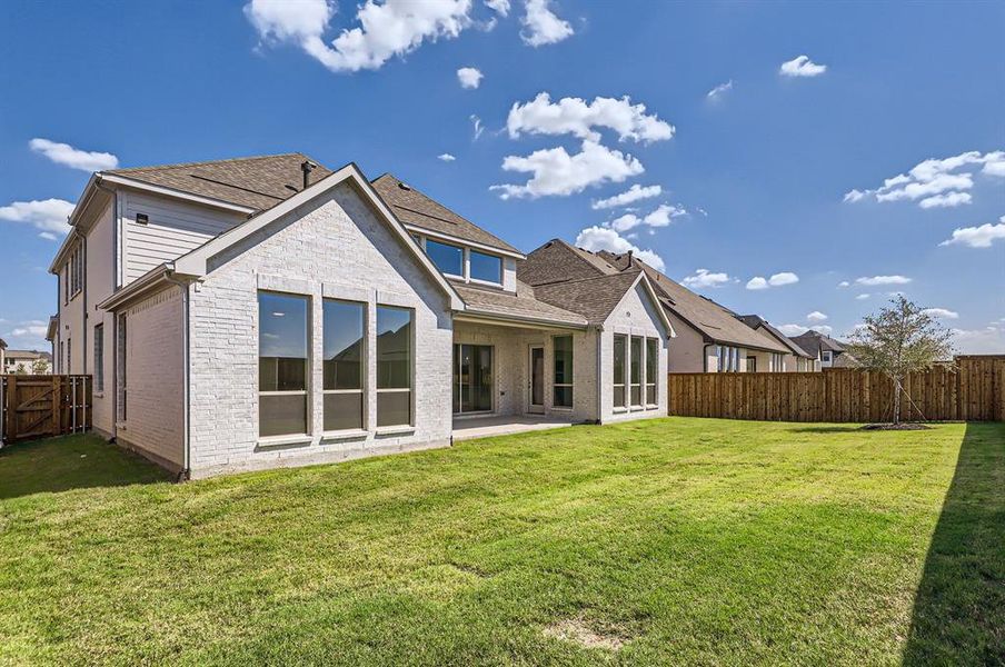 Rear view of house featuring a lawn