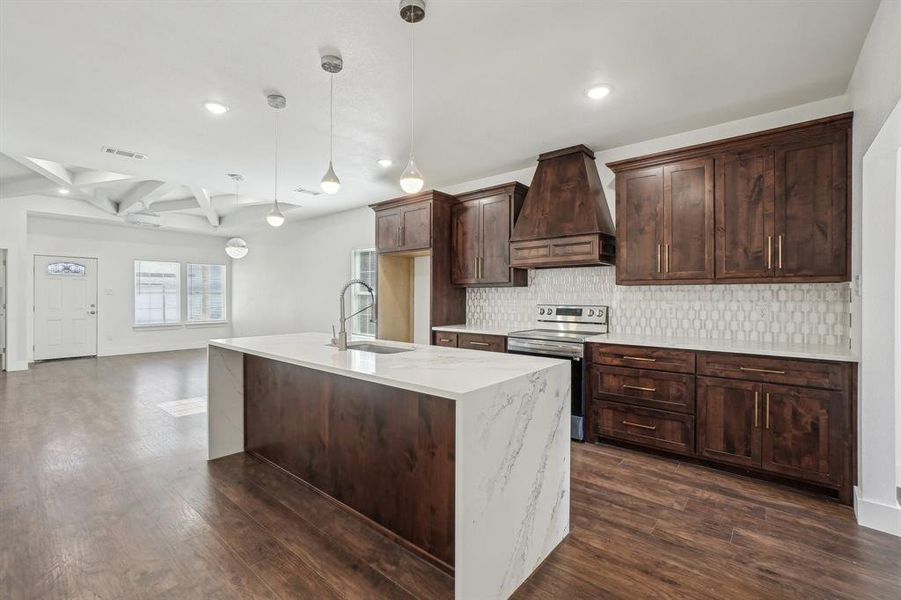 Kitchen featuring stainless steel electric range, custom exhaust hood, coffered ceiling, sink, and beamed ceiling