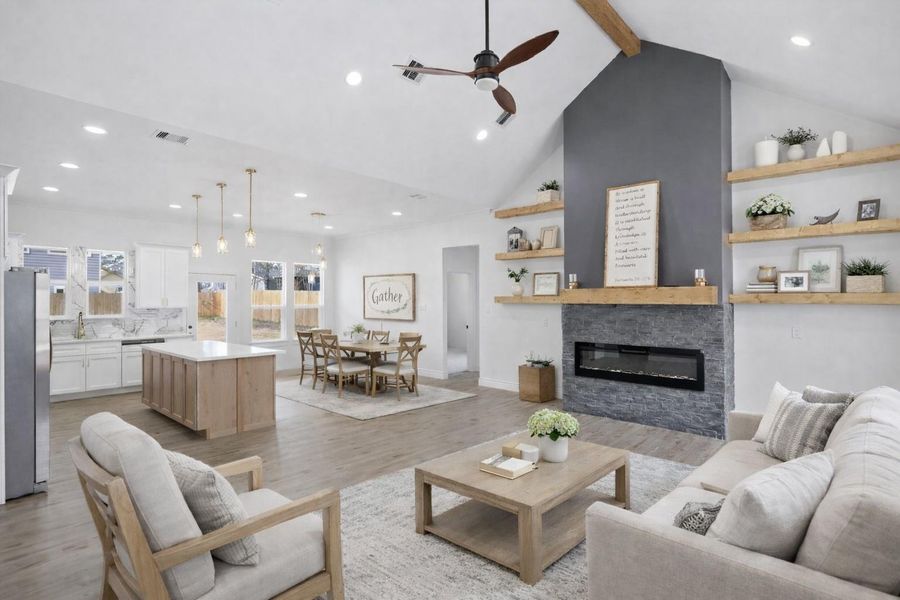 Open-concept living with soaring ceilings and a statement fireplace.