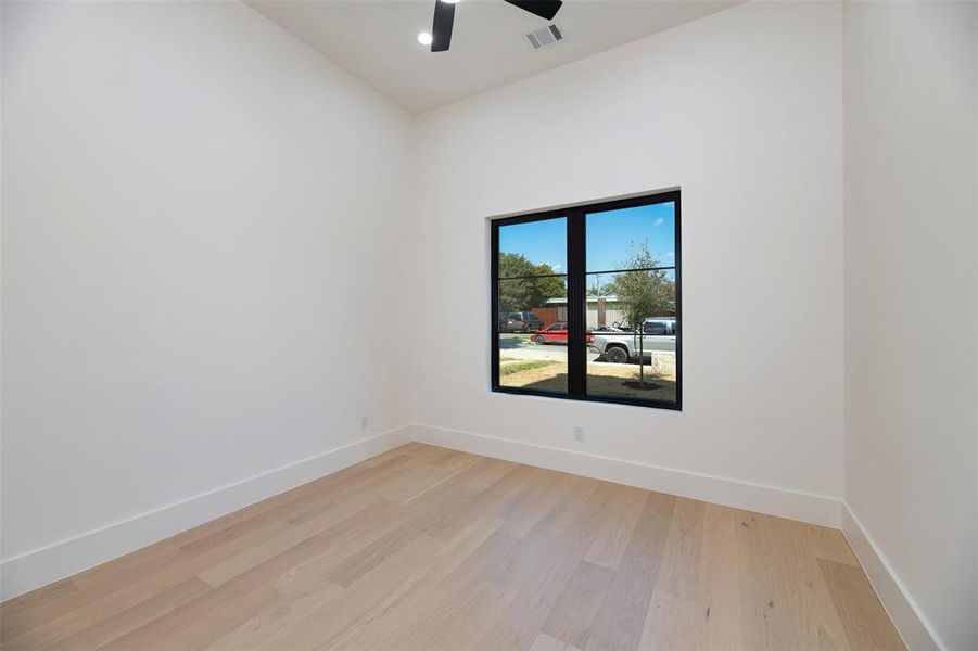 Empty room featuring light wood-type flooring and a ceiling fan Empty room featuring light wood-type flooring and a ceiling fan