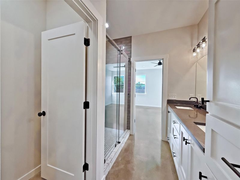 Primary Bathroom with polished concrete floors, double vanity, and a stall shower