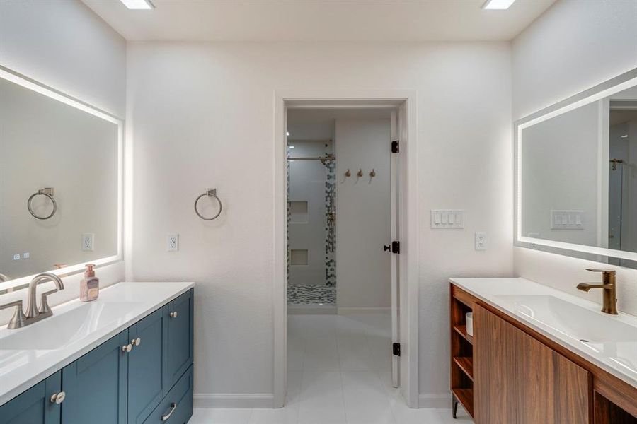 Bathroom featuring tile patterned floors, vanity, and a shower with shower door