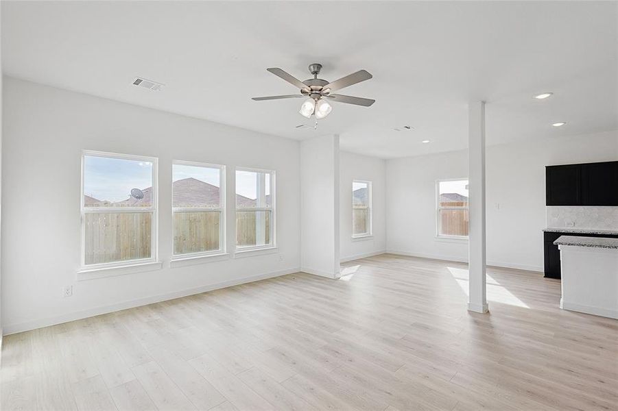 Unfurnished living room with light hardwood / wood-style floors and ceiling fan