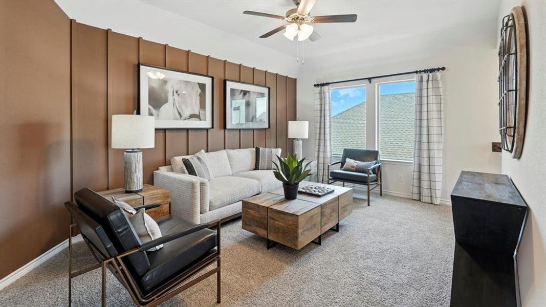 Living area featuring light carpet and a ceiling fan