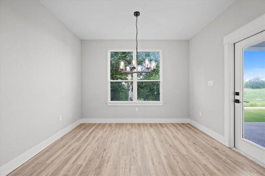 Unfurnished dining area featuring a chandelier and light wood-style flooring